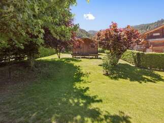 Discover this charming wooden cabin nestled in a lush green garden, perfect for a serene getaway.