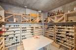 Discover this exceptional wine cellar, featuring extensive wooden shelving designed to store a vast collection of wine bottles.