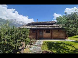 Nestled amidst breathtaking mountain scenery, this charming log cabin offers a rustic retreat with a distinctive slate roof.
