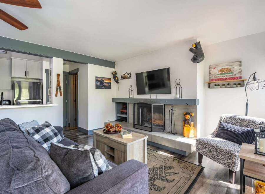 Cozy living room featuring a modern fireplace with a stone surround and a mounted flat-screen TV.