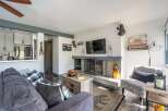 Cozy living room featuring a modern fireplace with a stone surround and a mounted flat-screen TV.
