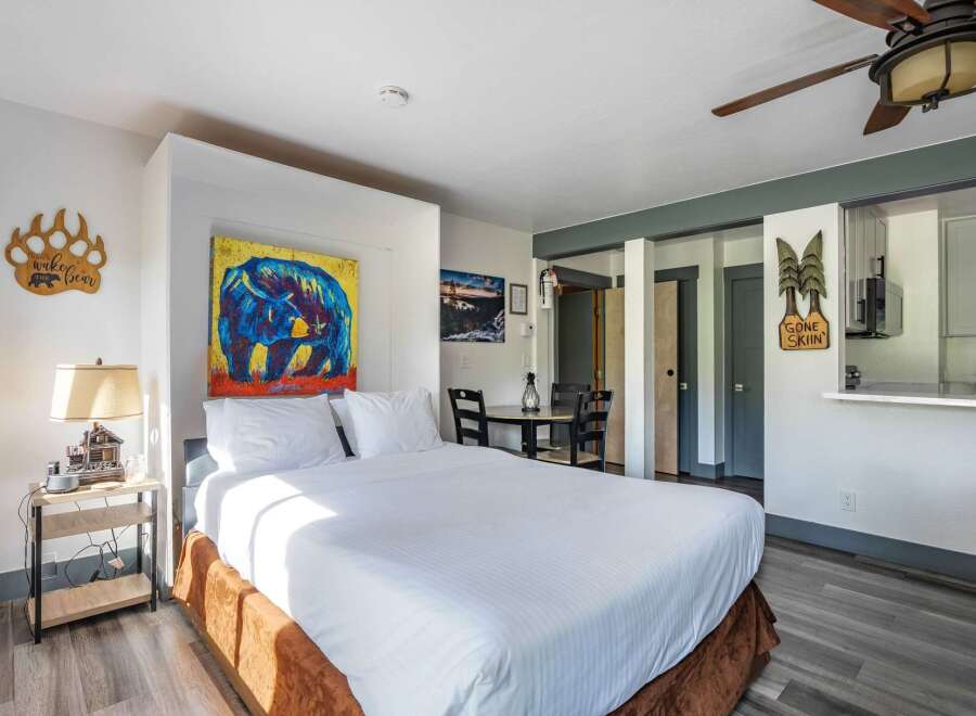 Experience cozy mountain living in this charming studio, featuring a comfortable queen-size bed and vibrant bear-themed artwork.