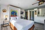 Experience cozy mountain living in this charming studio, featuring a comfortable queen-size bed and vibrant bear-themed artwork.