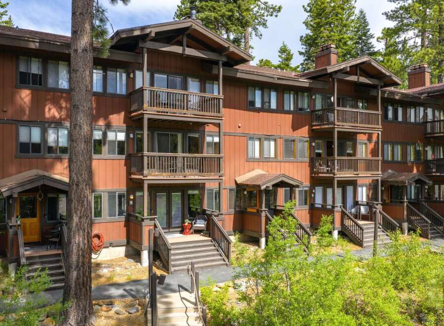 Discover this charming multi-level condo nestled amongst tall pine trees, offering a rustic mountain retreat.