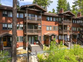 Discover this charming multi-level condo nestled amongst tall pine trees, offering a rustic mountain retreat.
