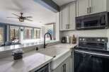 Experience modern comfort in this beautifully updated kitchen, featuring a farmhouse sink and sleek gray cabinetry.