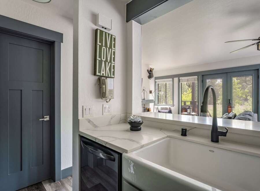 Discover this charming kitchen featuring a farmhouse sink and sleek quartz countertops, perfect for meal preparation.