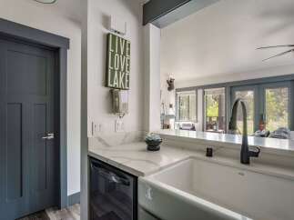 Discover this charming kitchen featuring a farmhouse sink and sleek quartz countertops, perfect for meal preparation.