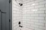 Experience modern elegance in this bathroom featuring a sleek subway tile shower and tub surround.
