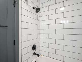 Experience modern elegance in this bathroom featuring a sleek subway tile shower and tub surround.