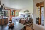 Experience rustic charm in this cozy bedroom featuring a comfortable queen-size bed adorned with bear-themed pillows and a patchwork quilt.