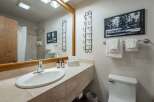 This charming bathroom features a spacious vanity with a marble countertop, a modern sink, and ample storage.