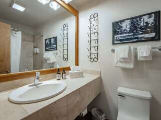 This charming bathroom features a spacious vanity with a marble countertop, a modern sink, and ample storage.