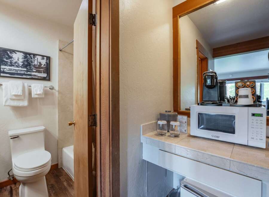 This hotel room offers a convenient kitchenette area featuring a microwave and coffee maker, perfect for preparing quick meals and beverages.