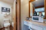This hotel room offers a convenient kitchenette area featuring a microwave and coffee maker, perfect for preparing quick meals and beverages.