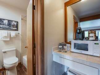 This hotel room offers a convenient kitchenette area featuring a microwave and coffee maker, perfect for preparing quick meals and beverages.