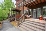 Discover this charming mountain retreat featuring a welcoming porch with comfortable seating and a vibrant orange accent table.