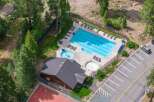 Experience resort-style living with this stunning aerial view showcasing a large swimming pool and a separate hot tub, perfect for relaxation and recreation.
