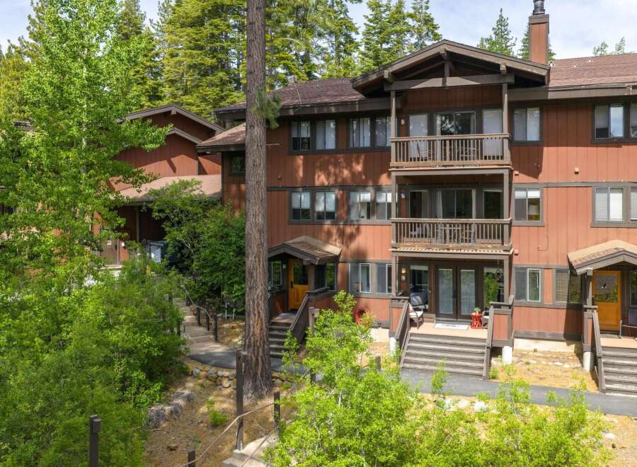 Nestled amidst towering trees, this charming multi-level residence offers a serene mountain retreat.