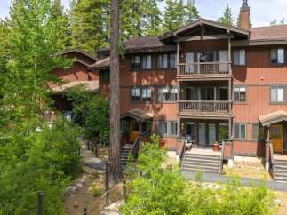Nestled amidst towering trees, this charming multi-level residence offers a serene mountain retreat.