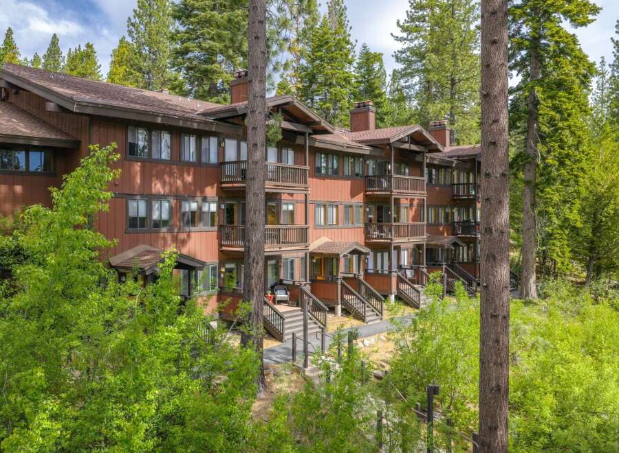 Nestled amidst towering pine trees, this charming multi-story condo offers a serene mountain retreat.