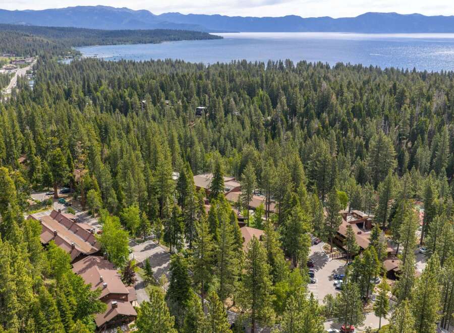 Nestled amidst a dense forest, this property offers a serene retreat with stunning views of a vast lake and distant mountains.