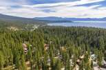 Nestled amidst a dense forest of pine trees, this property offers a serene retreat with stunning views of a distant lake and mountains.