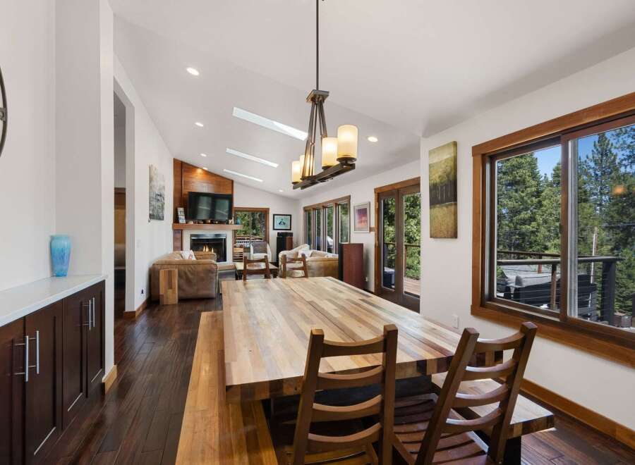 Experience rustic charm and modern comfort in this spacious dining and living area, featuring a large wooden dining table perfect for gatherings.