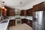 Experience luxury in this stunning kitchen featuring rich, dark wood cabinetry and sleek stainless steel appliances.