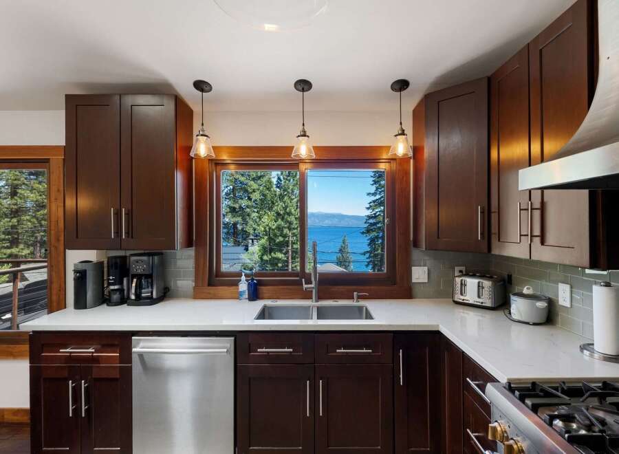 Experience breathtaking lake views from this stunning kitchen, featuring rich dark wood cabinetry and a spacious double sink.