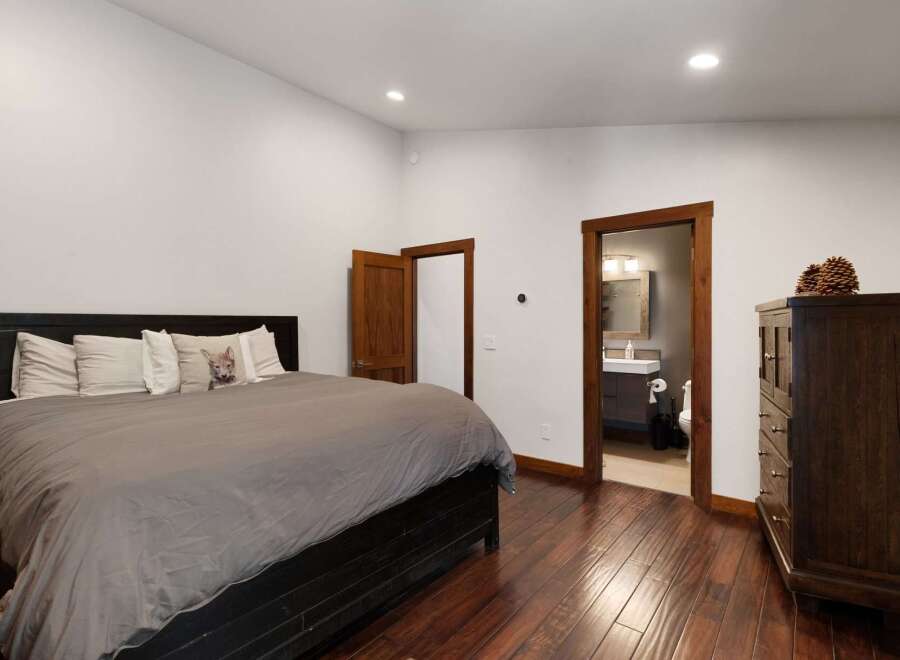 Experience comfort and style in this inviting bedroom, featuring a plush king-sized bed adorned with decorative pillows.