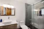 This modern bathroom features a sleek vanity with a vessel sink and a stylish wood-grain cabinet.