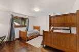 This cozy bedroom features a charming wooden bunk bed and a twin bed, perfect for accommodating family or guests.