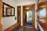 Step into a warm and inviting entryway featuring a stunning live-edge wooden bench and a unique striped mirror.
