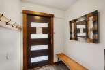 Step into a welcoming entryway featuring a stylish dark wood door with frosted glass panels, perfect for modern living.