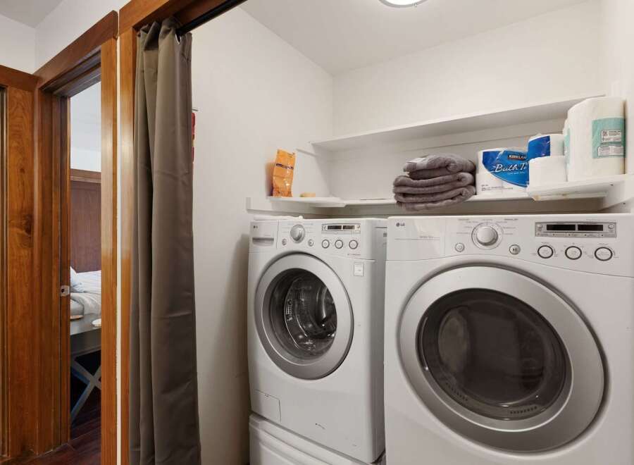 This laundry room features a stacked LG washer and dryer set, ensuring efficient and convenient laundry care.