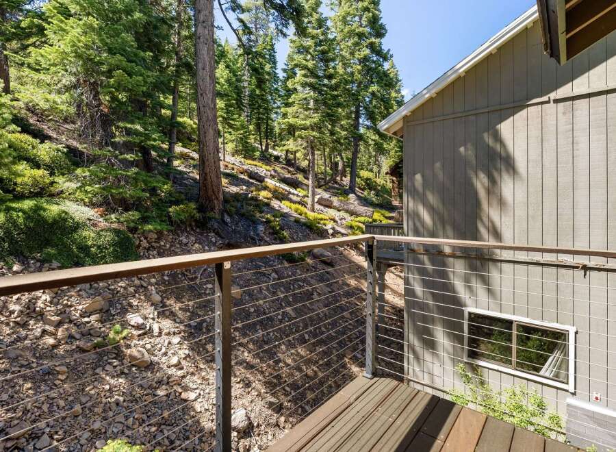 Experience the serene mountain lifestyle from this charming deck, offering a picturesque view of a lush, wooded hillside.