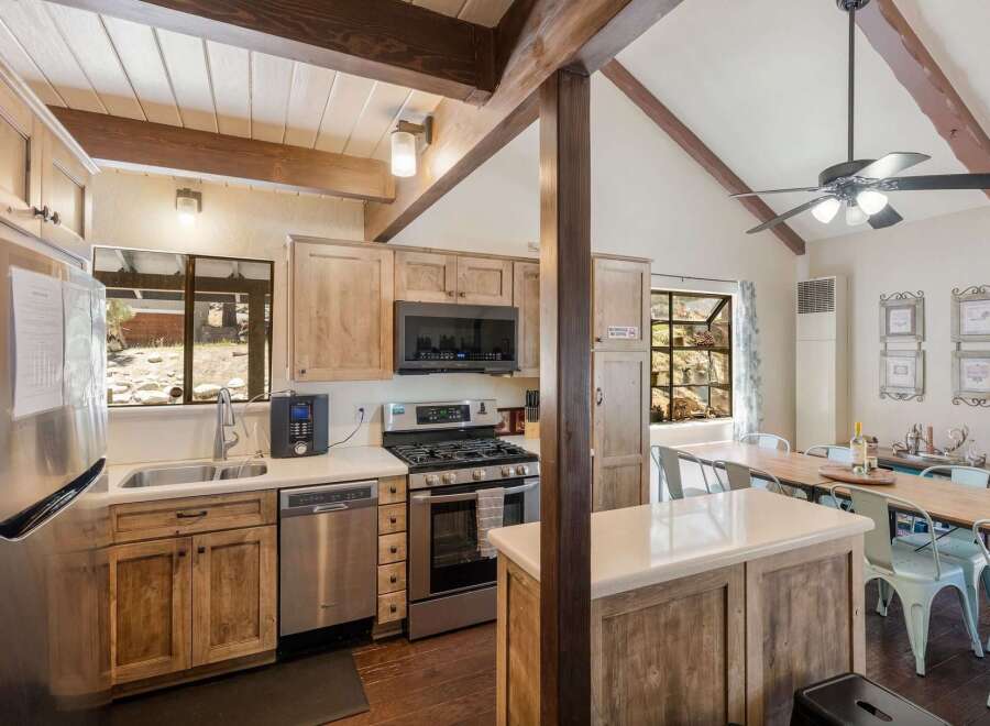 Experience rustic charm in this inviting kitchen featuring natural wood cabinetry and exposed beams, creating a warm and cozy atmosphere.