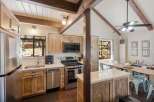 Experience rustic charm in this inviting kitchen featuring natural wood cabinetry and exposed beams, creating a warm and cozy atmosphere.