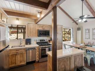 Experience rustic charm in this inviting kitchen featuring natural wood cabinetry and exposed beams, creating a warm and cozy atmosphere.