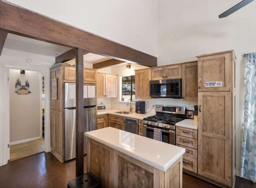 Experience rustic charm in this inviting kitchen featuring natural wood cabinetry and exposed beams.