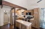Experience rustic charm in this inviting kitchen featuring natural wood cabinetry and exposed beams.