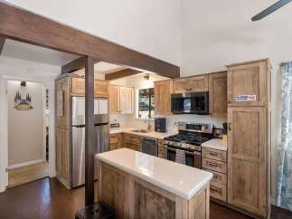 Experience rustic charm in this inviting kitchen featuring natural wood cabinetry and exposed beams.