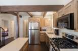 Discover this charming kitchen featuring rustic wooden cabinetry and a sleek stainless steel refrigerator.