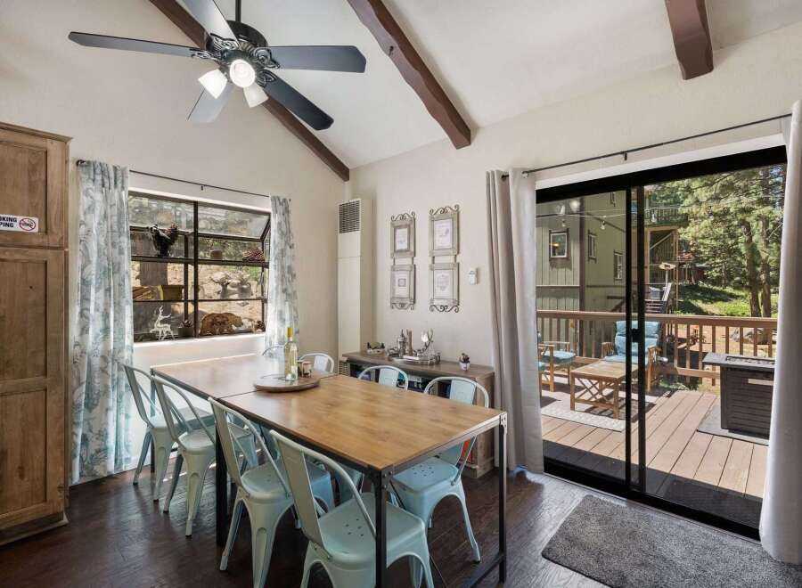 Enjoy meals with a view in this charming dining area, featuring a rustic wooden table and light blue chairs.