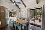 Enjoy meals with a view in this charming dining area, featuring a rustic wooden table and light blue chairs.