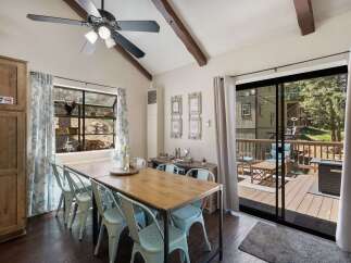 Enjoy meals with a view in this charming dining area, featuring a rustic wooden table and light blue chairs.