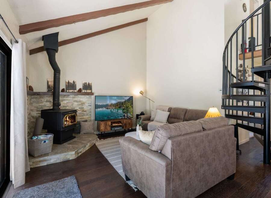 Cozy living room featuring a stone-clad fireplace with a wood-burning stove, perfect for chilly evenings.