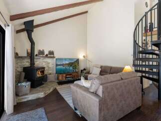 Cozy living room featuring a stone-clad fireplace with a wood-burning stove, perfect for chilly evenings.