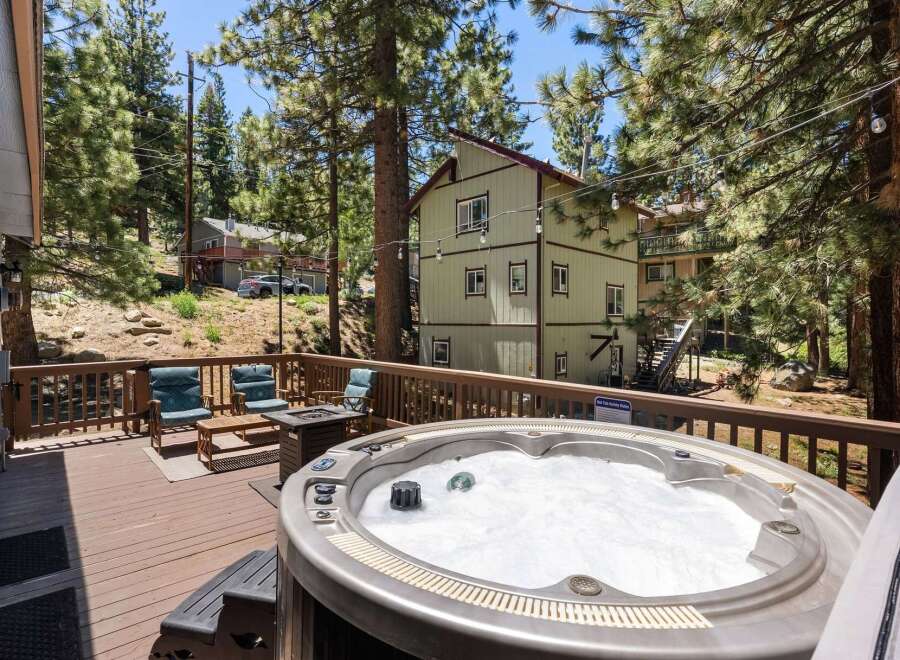 Relax and unwind in this stunning mountain retreat, featuring a spacious deck with a bubbling hot tub perfect for soaking up the scenic views.